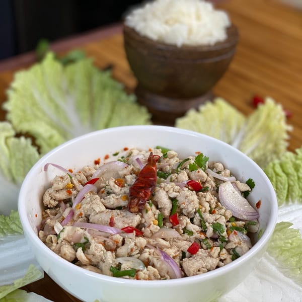 Thai Larb Gai, a minced chicken salad with red onions, chili, and cilantro, served with lettuce and rice.