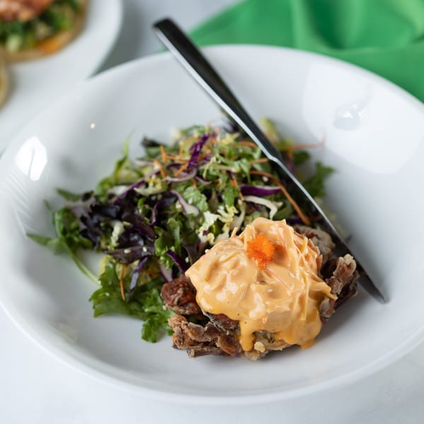Crispy soft-shell crab with creamy orange sauce and orange roe, served with a fresh green salad.